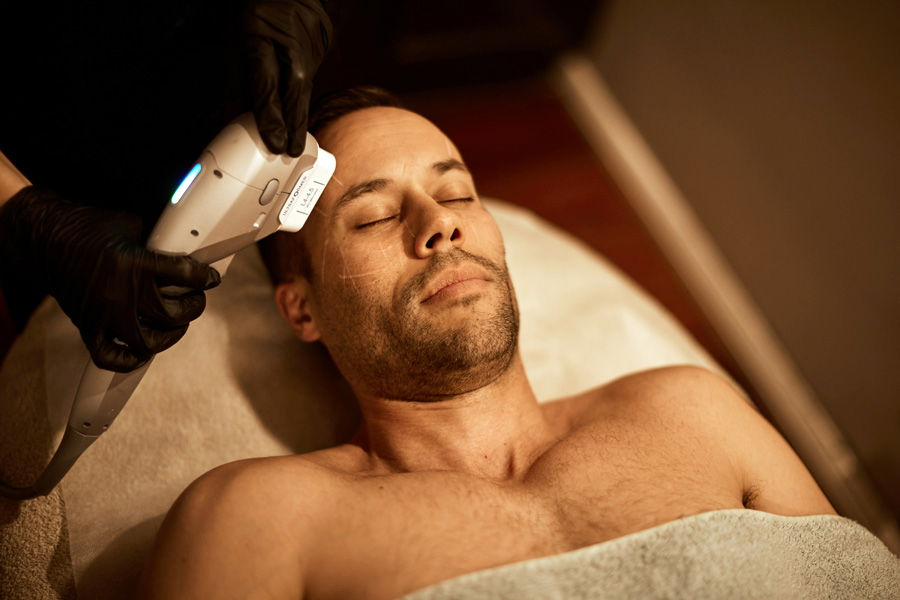 Sydney man receiving ultraformer treatment at face of man